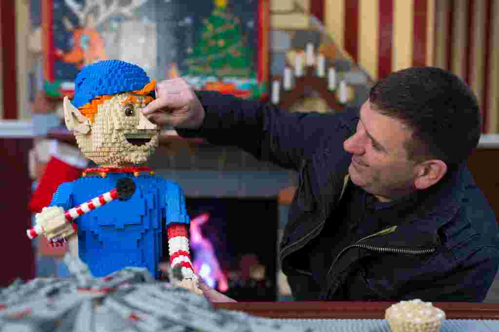 Duncan Titmarsh the UK's only LEGO Certified Professional Builder puts the finishing touches to the LEGO Santa's Workshop in Covent Garden. Photography David Parry/PA Wire