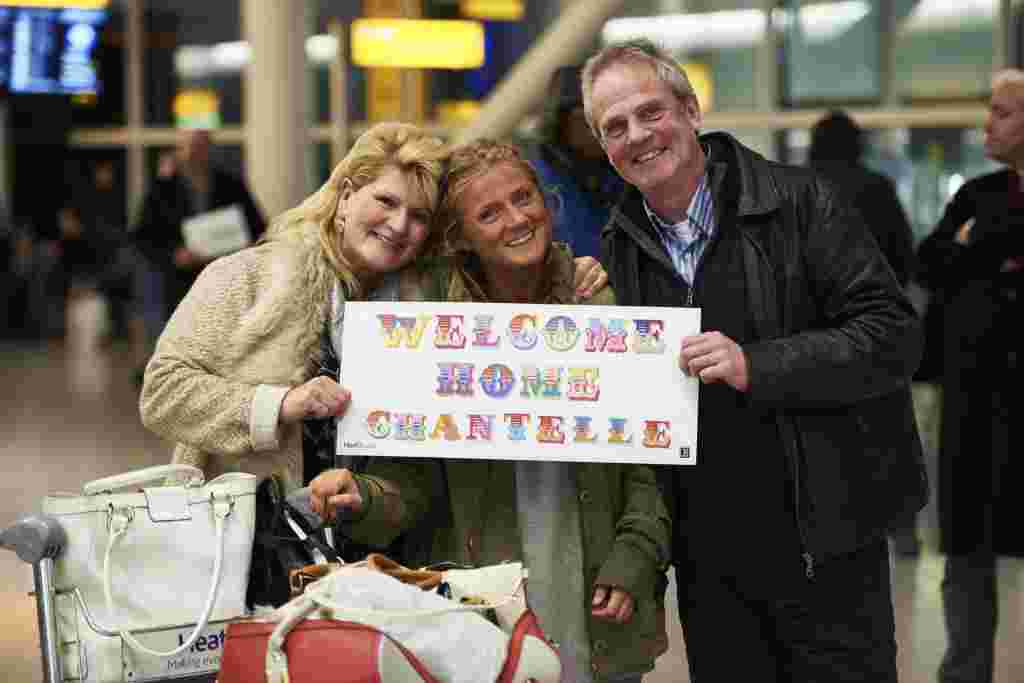 Heathrow Terminal 2, Tuesday 6th December, 2016: Loving parents greet daughter Chantelle on her return from year long travels with welcome home banner at Heathrow Terminal 2  This Christmas, Heathrow is giving every passenger the chance to have their own heartfelt reunion in arrivals just as teddy bears Doris and Edward* did in their Christmas film. To celebrate those tender moments, the airport has partnered with prolific London-based street artist, Ben Eine, to create a range of personalised banners, for family and friends to make greeting their loved ones extra special this year. PR Handout - free for editorial usage. For more information, an interview with Ben Eine or further images please contact Emily.Stallard@onegreenbean.com/ 0207 467 9246.  Copyright: © Mikael Buck / Heathrow