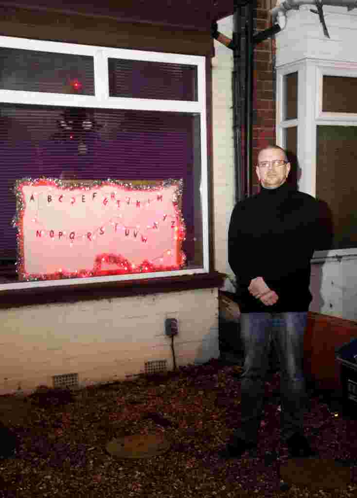 Giles Wallwork with his 'Stanger Things' Christmas display.  A house in Birmingham is captivating passers-by with its Stranger Things-inspired festive light display in the front window.  See NTI story NTISTRANGER.  The flashing lights scroll through the letters to spell out Merry Christmas in a homage to the popular Netflix show, starring Winona Ryder.  The man behind it - Giles Wallwork - said he had the idea in November and looked up blueprints on how to get the lights to work.